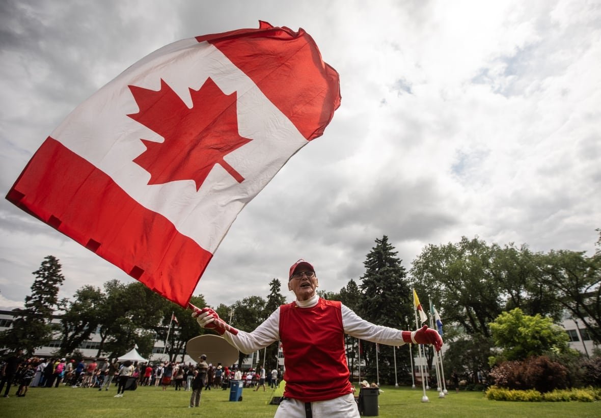 Henry Stephens waves a flag during Canada Day celebrations in Edmonton on Monday July 1, 2024. THE CANADIAN PRESS/Jason Franson