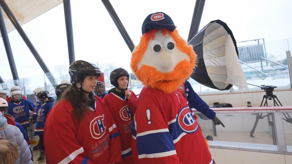 A mascot wearning the Montreal Canadiens jersey skates next to kids.