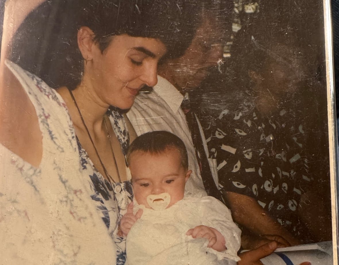 jennifer-craft-and-her-daughter-melanie A time-worn photo of a woman cradling a baby.