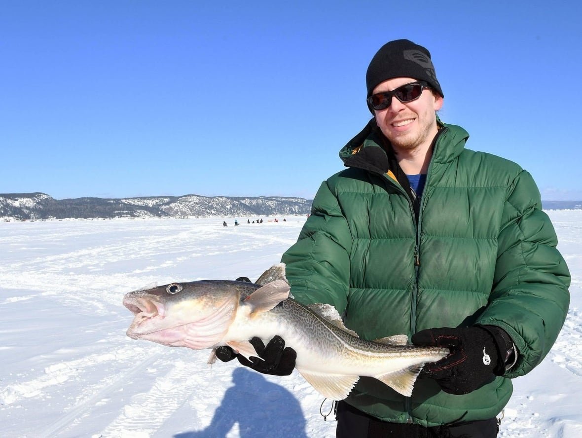 A man holds up a fish