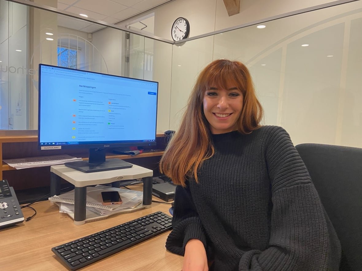 A woman sits in front of a computer.