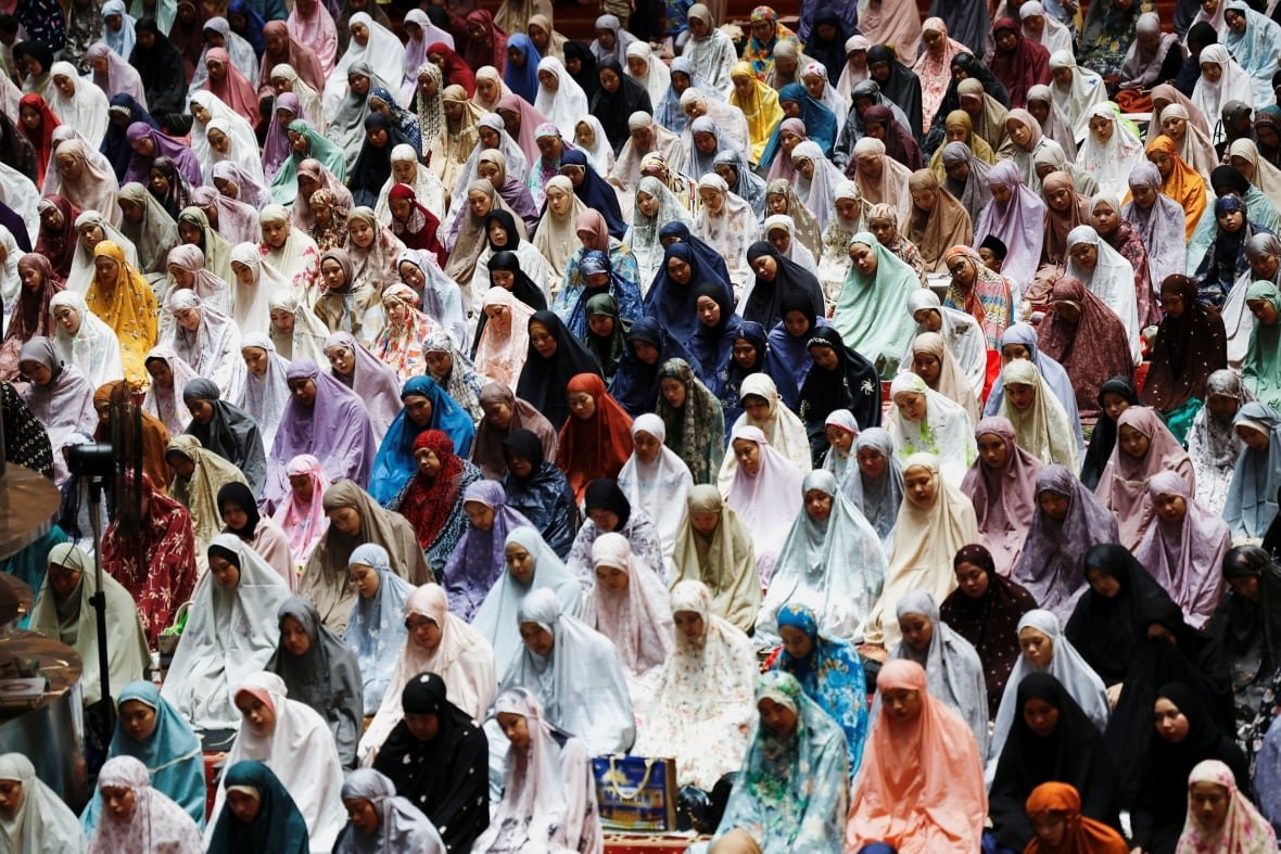 Muslim women take part in a mass evening prayer
