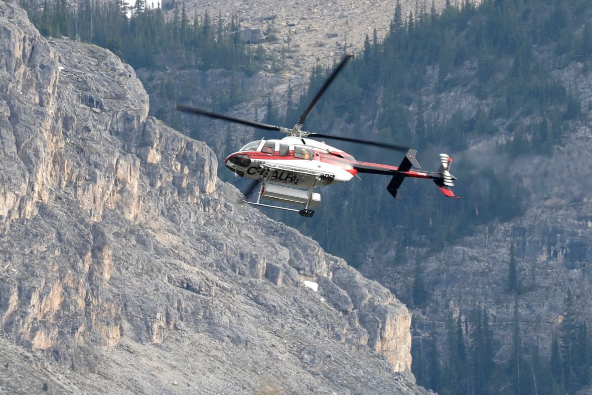 alta-rock-slide-20250619 a helicopter flies in front of a mountainside