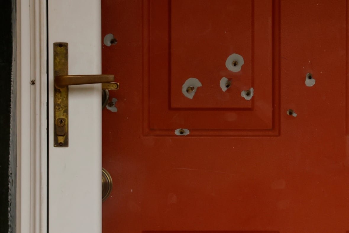aptopix-minnesota-lawmaker-shot-1 A closeup of a red door to a residence is shown, with several bullet holes in the door.