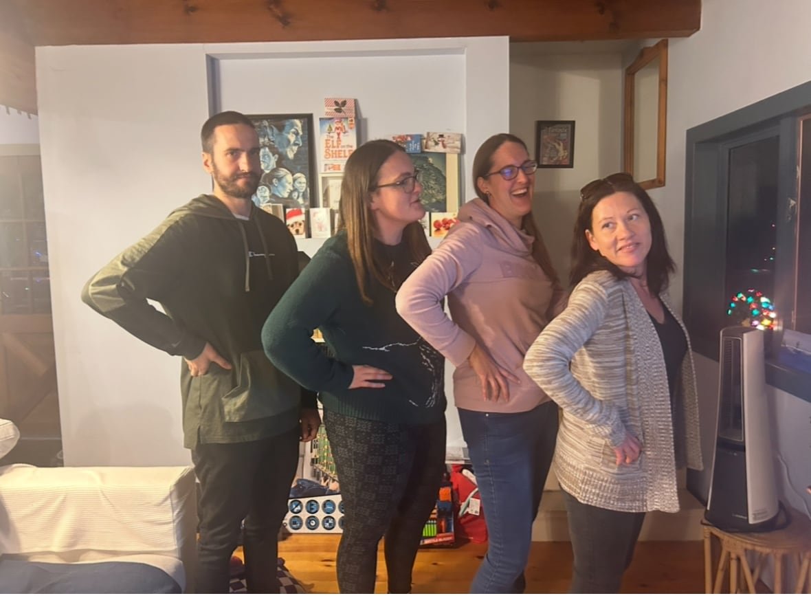 A portrait of four people lined up in a home.