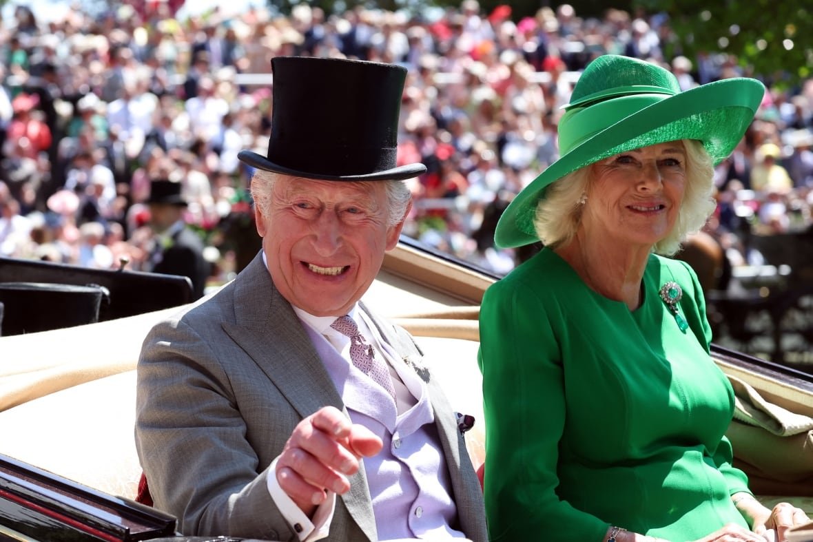 horseracing-ascot-1 A man and woman in formalwear ride in a carriage