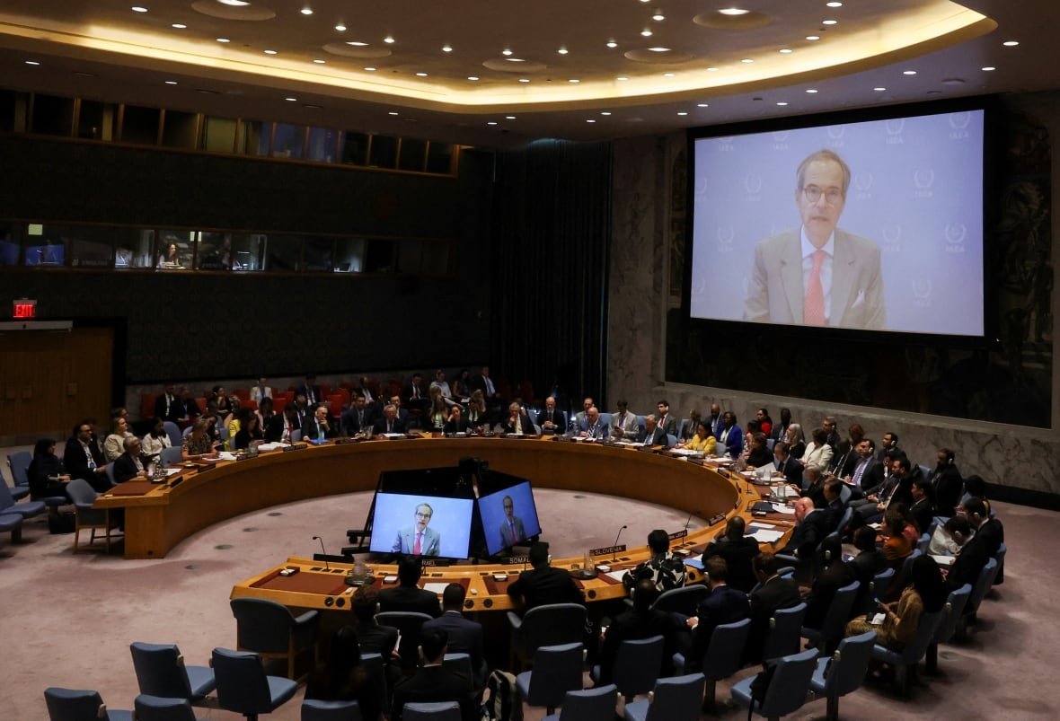 iran-nuclear-un A council of people watch a video screen on which a man in a suit speaks