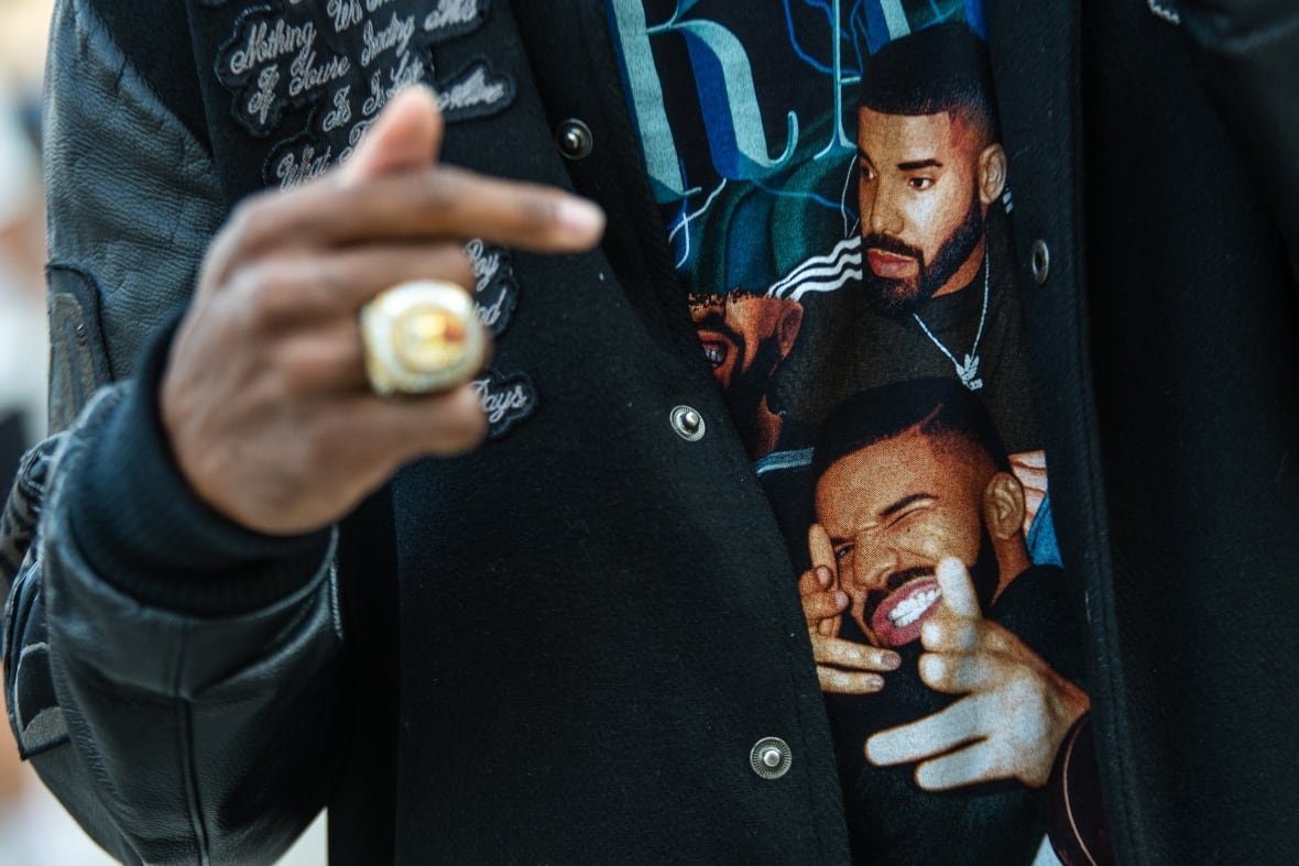 A man wears a t-shirt with Drake on it