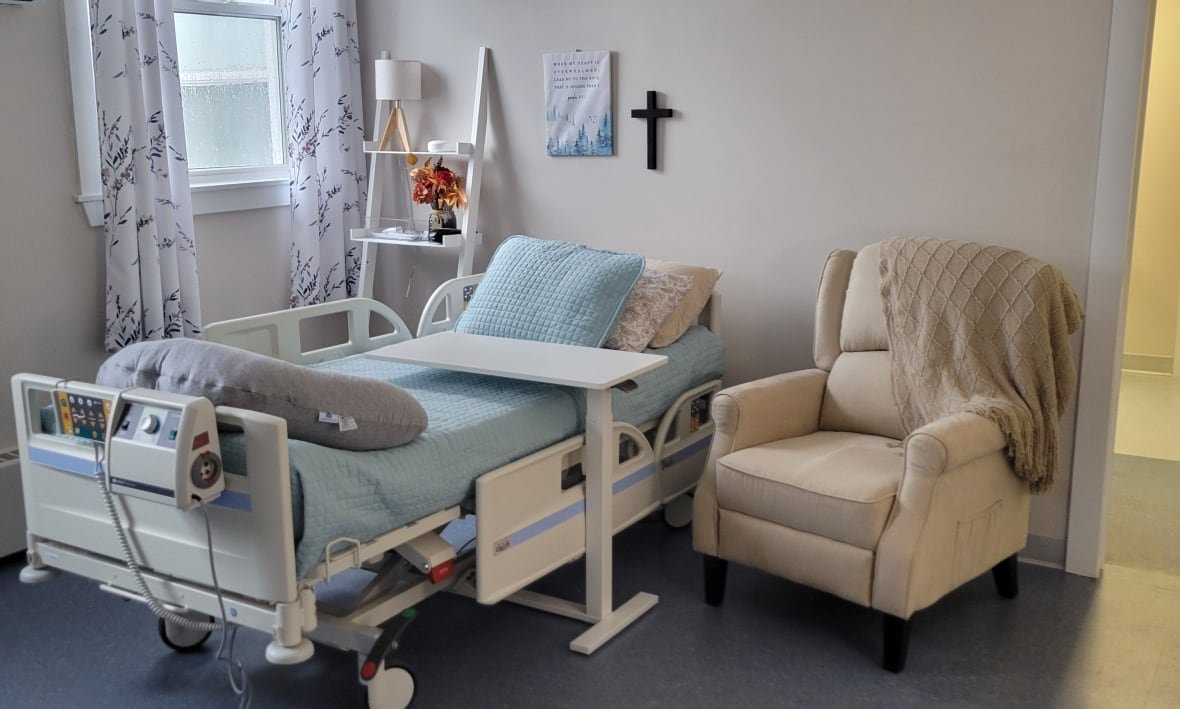 palliative-care-room-bed A nursing home bed next to a beige armchair.