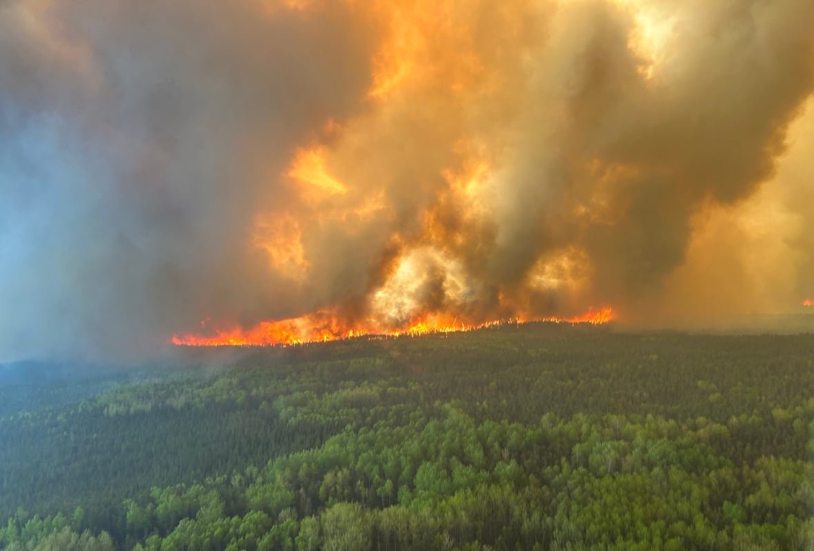 red-lake-12-wildfire-1 An aerial view of a wildfire seen burning through a green forest.