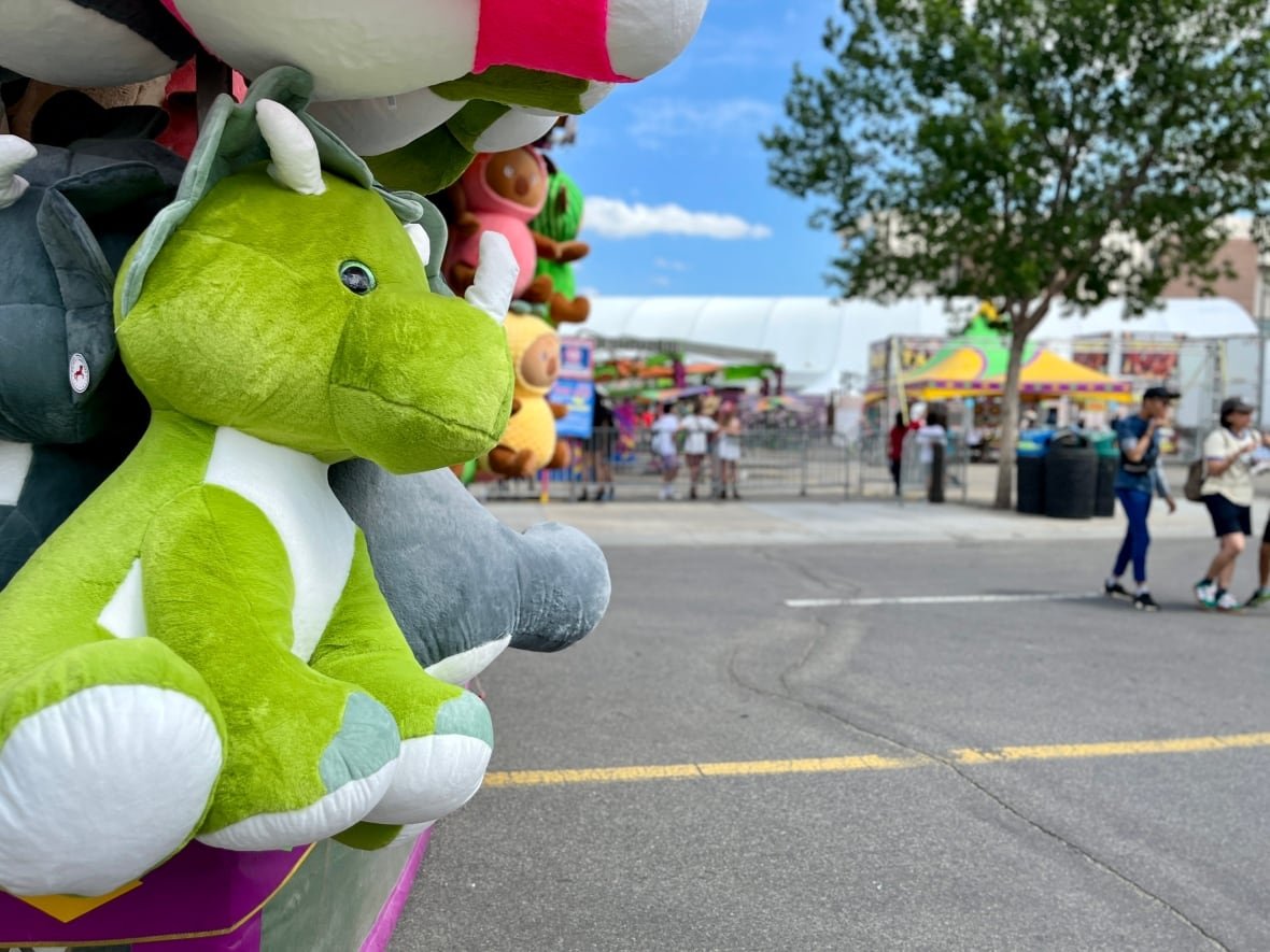 cgy-stampede-2025-2 A green dinosaur stuffed animal is shown at the midway.
