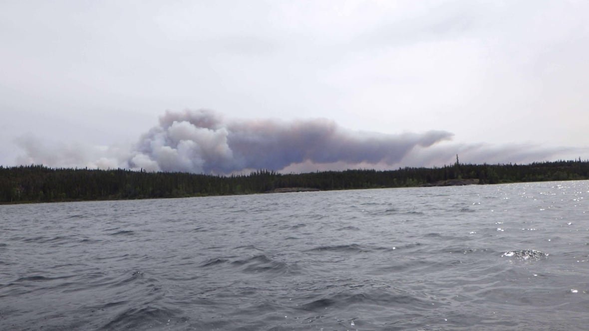 hearne-lake-fire A plume of smoke beside a lake.
