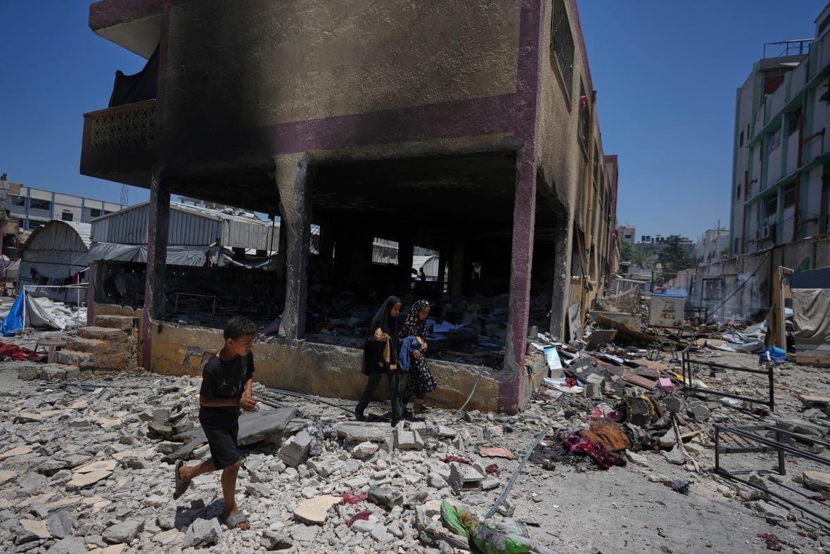 israel-palestinians-1 Children survey the destruction at a school.