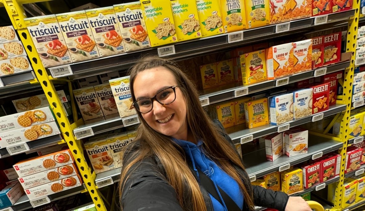 A woman takes a selfie in  a grocery store aisle