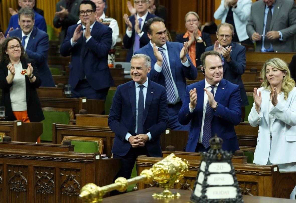 major-projects-bill-20250620-1 People stand and clap in a legislative hall.