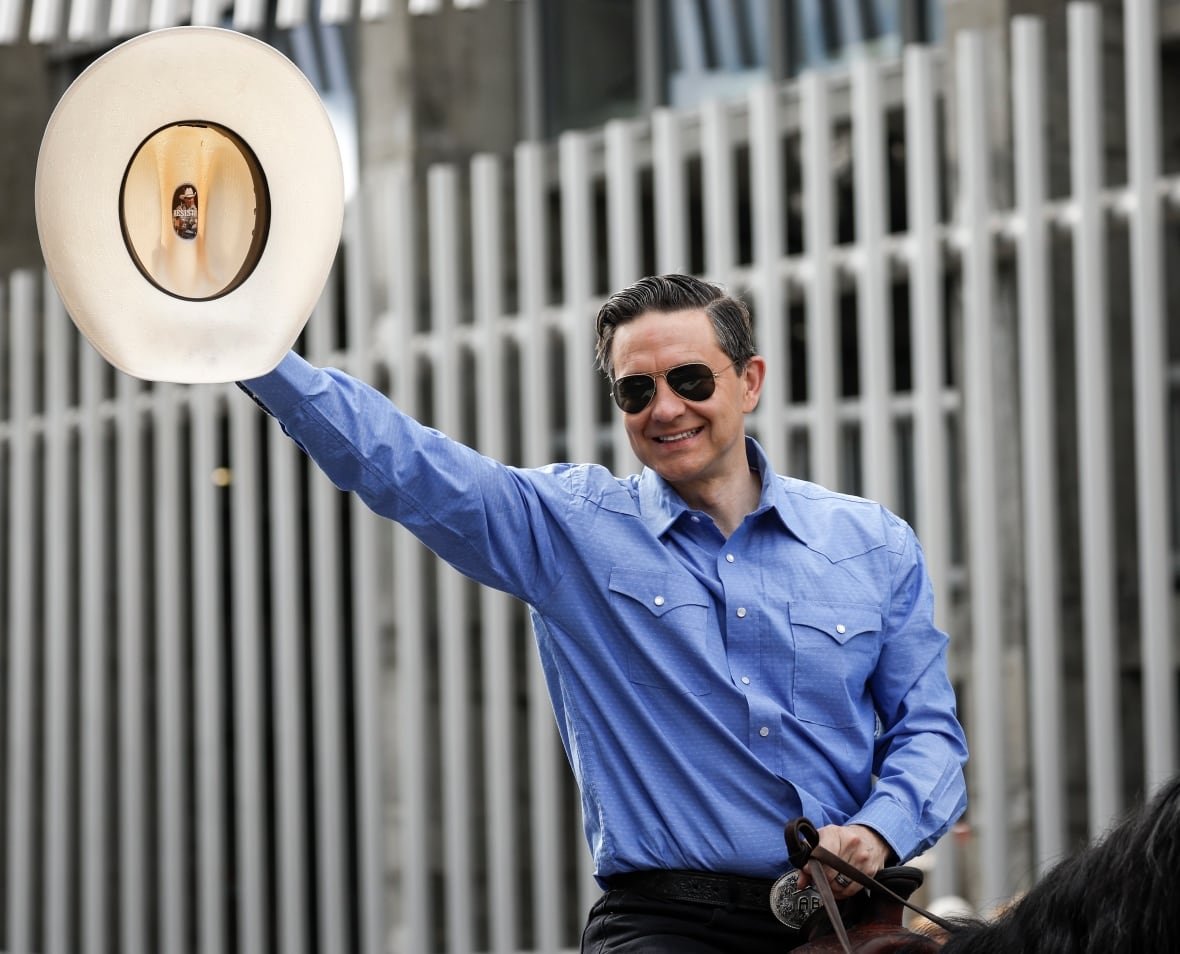 Conservative Leader Pierre Poilievre waves to the crowd as he rides in the Calgary Stampede parade.
