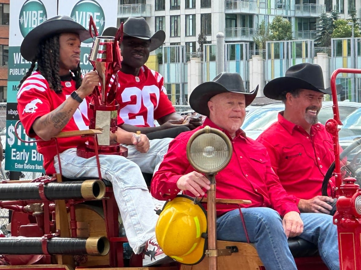 Two Calgary Stampeders enjoy cheers from the crowd.