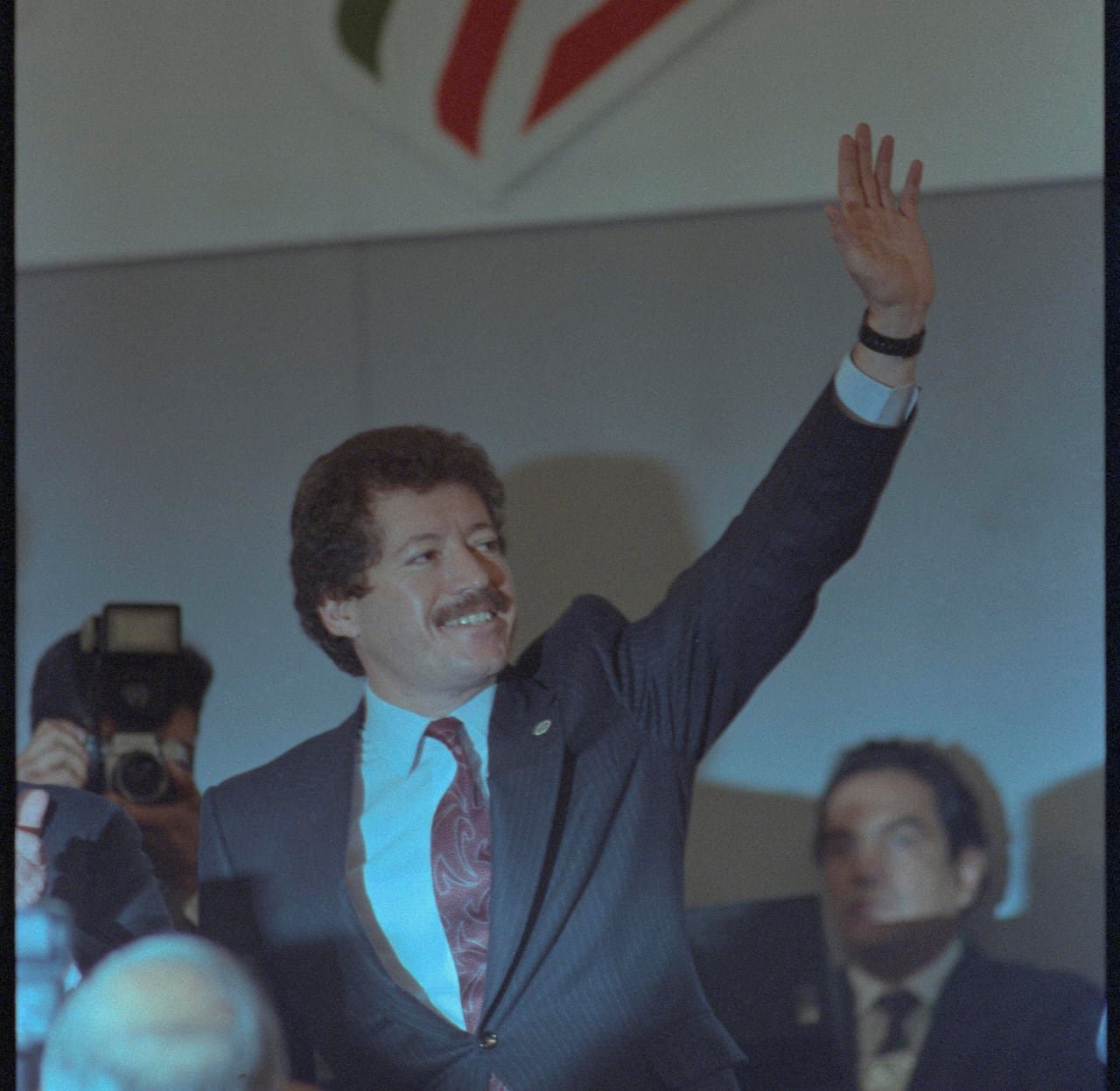 A man waves from a stage to the crowd