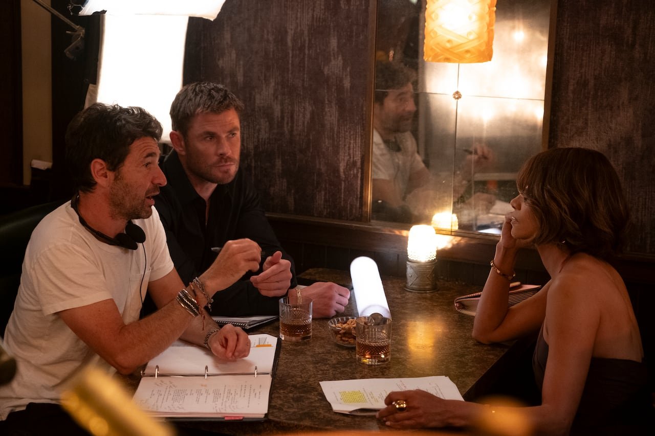 default-658 Three people sit at a restaurant table. On the table are scripts with highlighted text on them.