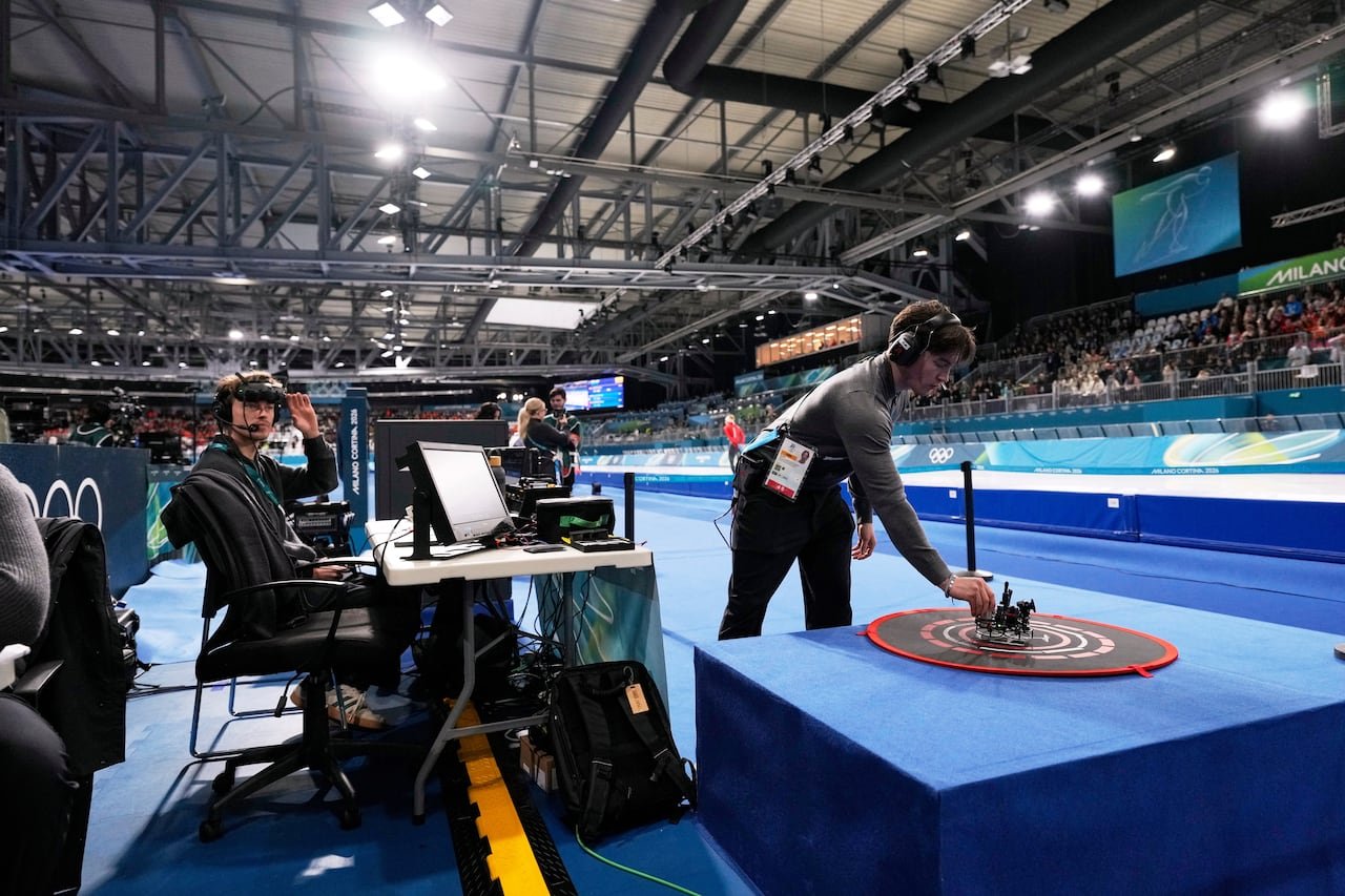 default-710 A person touches a drone that is sitting in several circles on a flat surface in an ice rink.