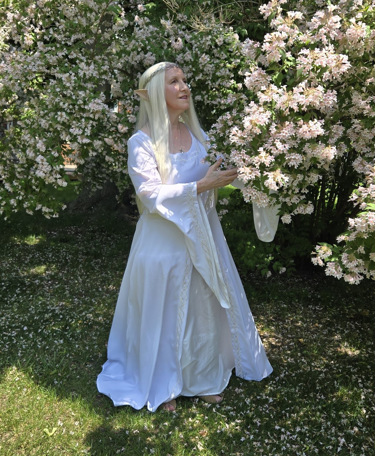 default-332 A woman is dressed in a white dress with a long blonde wig and pointed ears