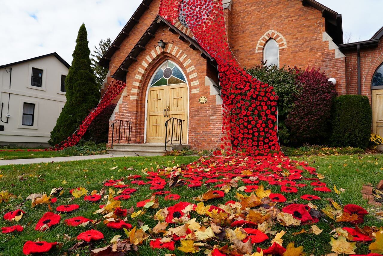 knitted poppies draping the entrance of a church