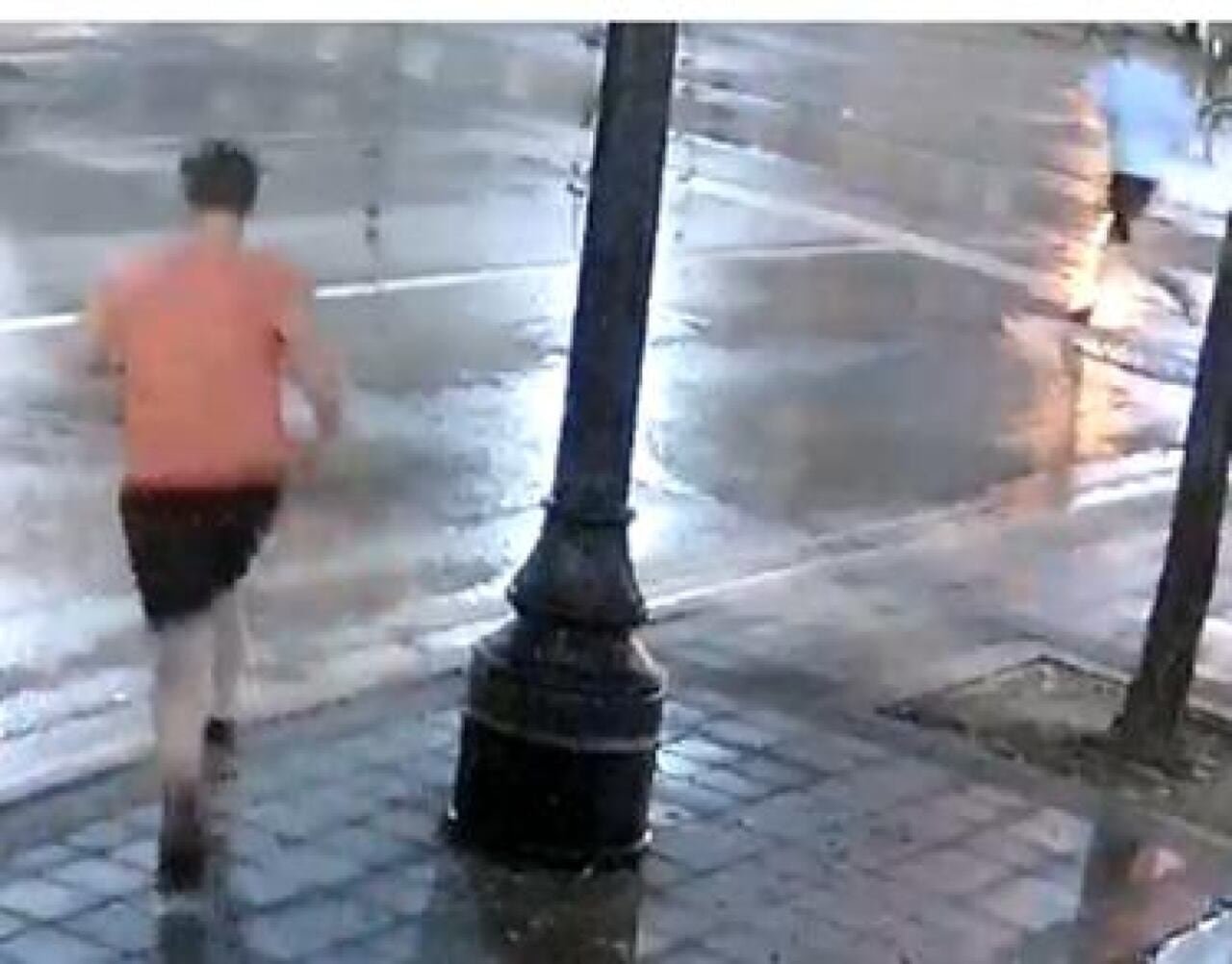 People run down a wet street.