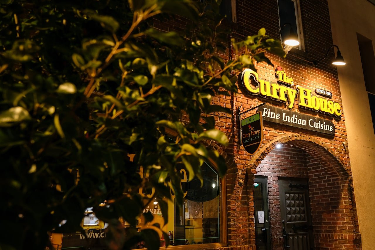 The exterior of a restaurant called The Curry House is shown at night.