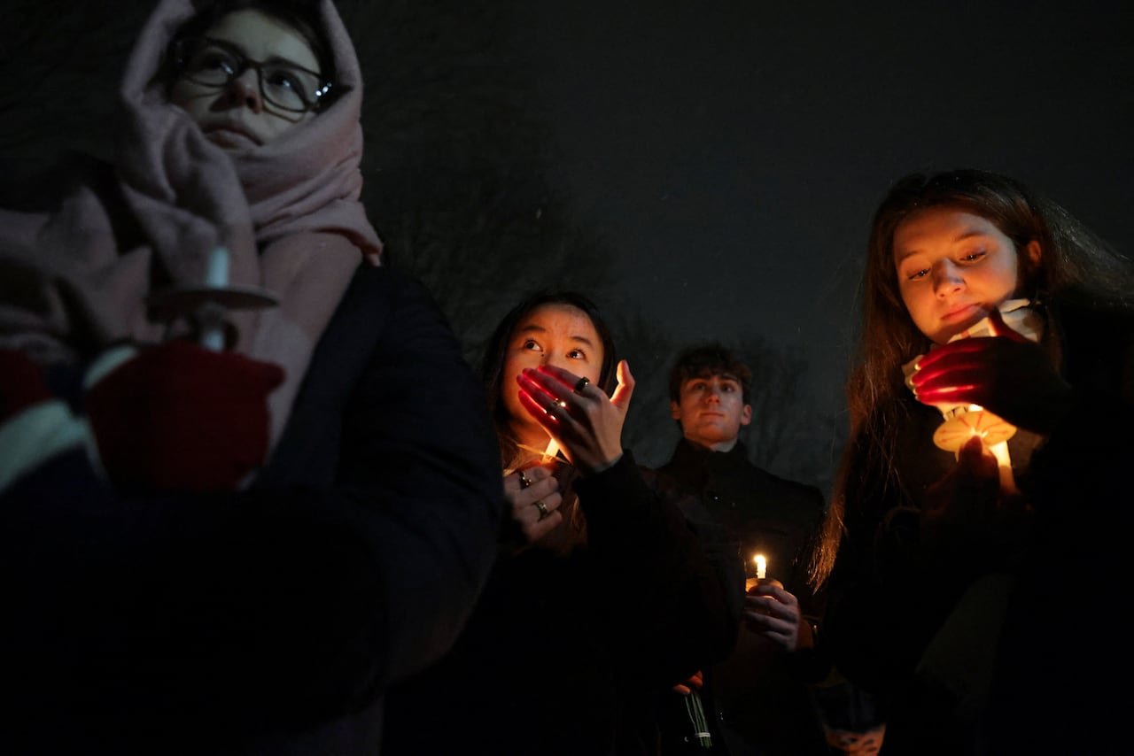 People gather for a vigil in memory of the Brown University shooting victims