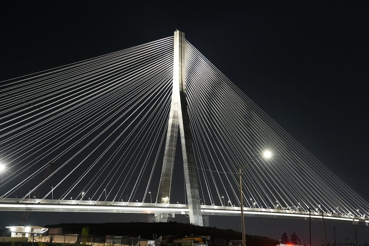 The cables of the Gordie Howe bridge illuminated against the night sky
