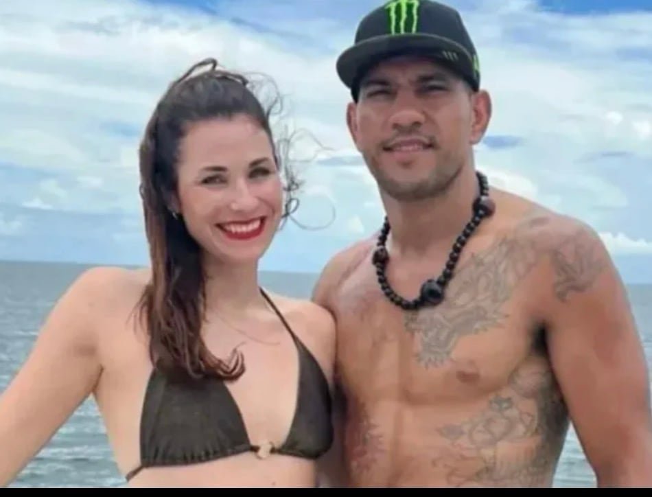 default-296 A woman in a bikini and a shirtless man in a Monster Energy drink hat pose for a photo.