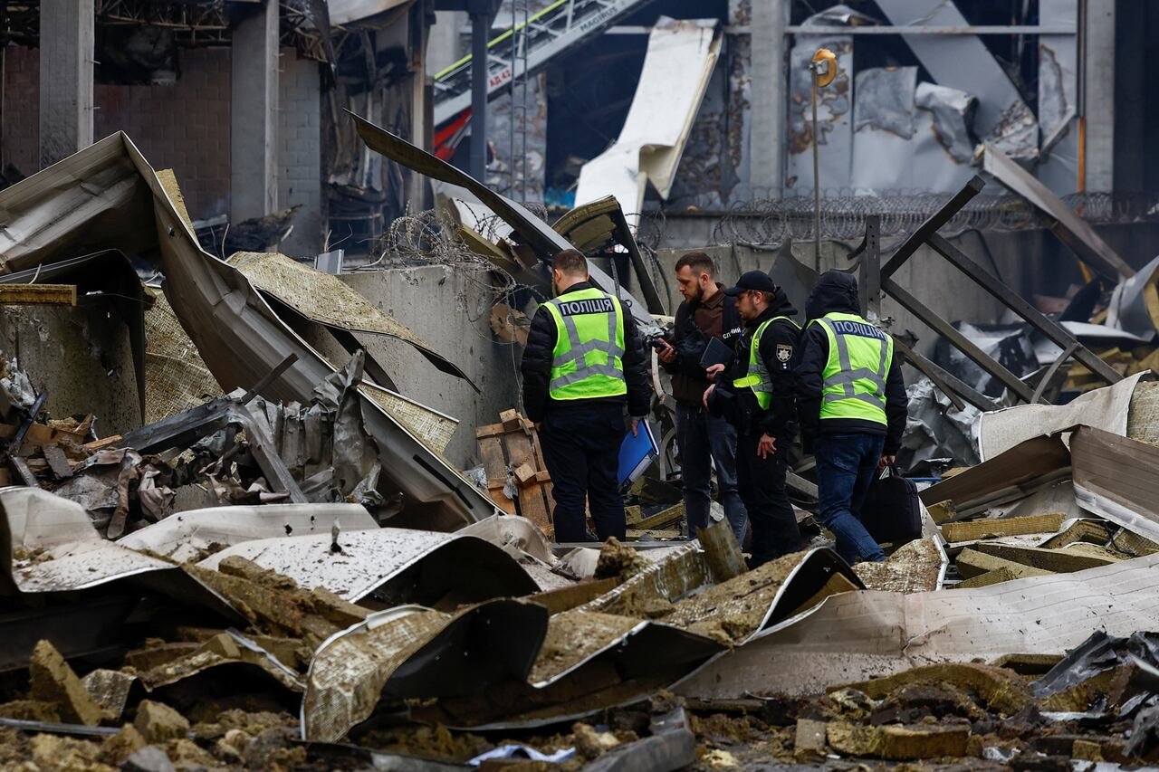 default-77 Police investigators stand on top of rubble.