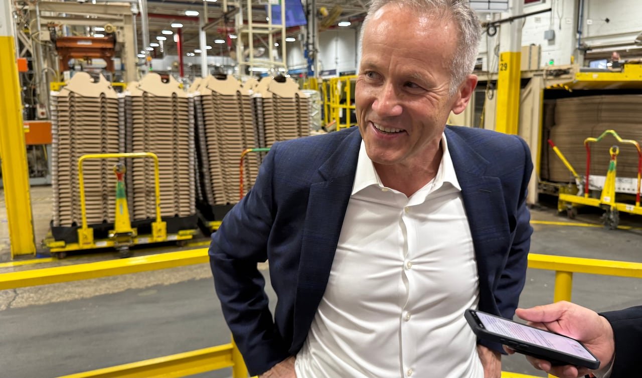 Marc Bitzer standing inside a factory that makes washing machines.